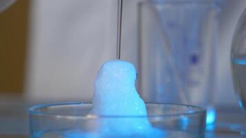 químico reacción en volumétrico matraz vaso en laboratorio. el químico rosado reactivo en un transparente botella. químico reacción cerca arriba video