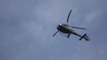 hélicoptère dans le nuageux ciel avec foudre. hélicoptère de au dessous de en volant par nuageux ciel. hélicoptère planant contre brillant ensoleillé et nuageux ciel video