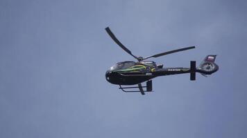 helikopter in de bewolkt lucht met bliksem. helikopter van hieronder vliegend door bewolkt lucht. helikopter zweven tegen helder zonnig en bewolkt lucht video