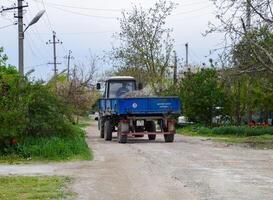 tractor with a rubble cart for repairing the road. Feeding holes on the road. Street repair. photo