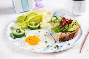 Romantic breakfast for Valentine's Day. Fried egg and toast with avocado and cream cheese. photo