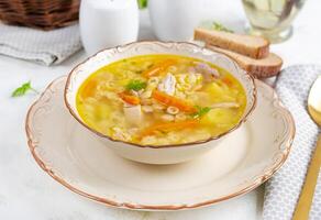 Fresh chicken soup with vegetables and stelline pasta in a bowl with carrot and parsley. photo