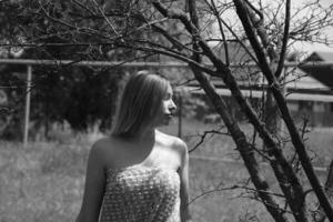 Black and white photo, girl in the garden on a meadow in a dress. photo