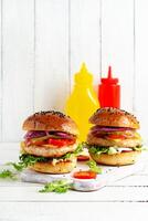 Chicken hamburger. Sandwich with chicken burger, tomatoes, cheese, pickled cucumber and lettuce. Cheeseburger. photo