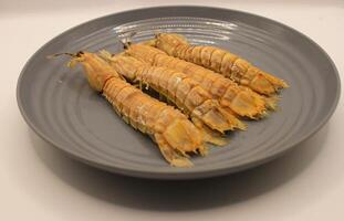 Fresh mantis shrimp on a plate, closeup of photo. photo