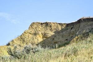 Breakage of the rock. The layers of clay and soil are visible. Clayey place photo