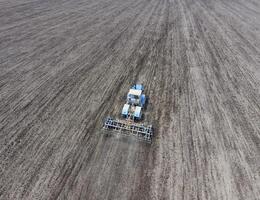 cultivo de suelo para el siembra de cereales. tractor arados el suelo en el campo foto