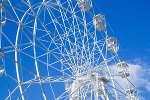 White ferris wheel against the blue sky. Ferris wheel in the park photo