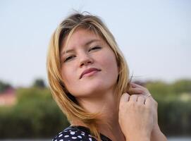 Portrait of a beautiful blonde against a background of green cane. photo