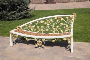 Street bench with forged patterns. Blacksmith's product. Art in a forged bench. photo