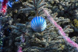 decoraciones nuevo año árbol. oropel y juguetes, pelotas y otro decoraciones en el Navidad Navidad árbol en pie en el abierto aire. foto