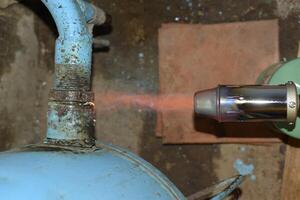 Heating a steel pipe with a blowtorch. The flame of a blowtorch photo