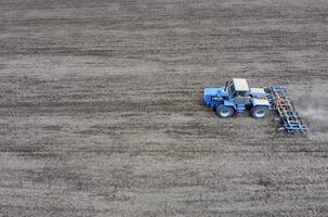 Cultivation of soil for the sowing of cereals. Tractor plows the soil on the field photo