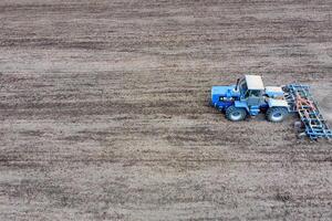 cultivo de suelo para el siembra de cereales. tractor arados el suelo en el campo foto