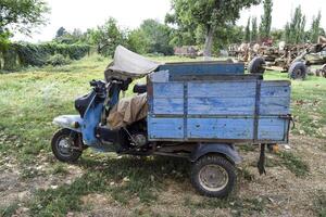 scooter hormiga. antiguo Soviético motor scooter en Tres ruedas con un carro foto