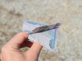 Denominations of Russian money, folded in the airplane in hand photo