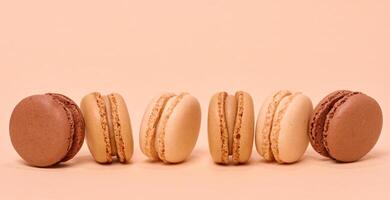 Chocolate macarons on a beige background, dessert photo