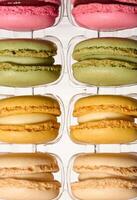 Macarons in plastic box on isolated background, top view photo