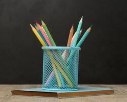 Multi-colored wooden pencils on a black chalk board background photo