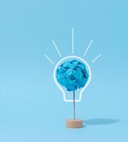 A crumpled ball of blue paper, a drawn electric lamp. photo