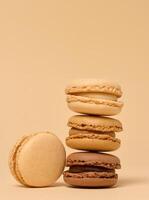 Stack of chocolate macarons on beige background photo