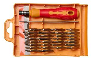 Plastic box with screwdriver and various bits for screws on isolated background photo