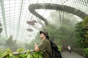 a man in Cloud Forest dome environment at Gardens in Singapore photo