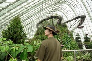 a man in Cloud Forest dome environment at Gardens in Singapore photo