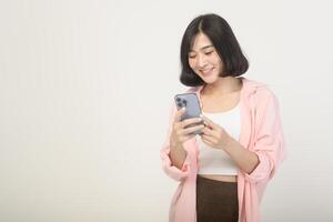 Young asian woman using smartphone over white background, technology concept photo