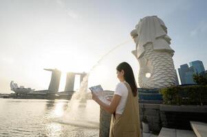 a woman in Merlion fountain in front of the Marina Bay photo