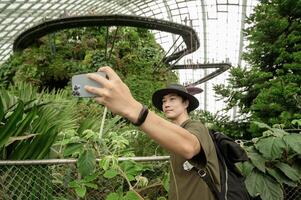 a man in Cloud Forest dome environment at Gardens in Singapore photo
