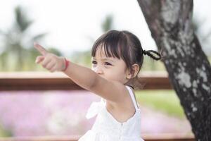 A happy young girl admires and gently touches and admires a blooming flower. It reflects the beauty of spring and the simple pleasures of being in contact with nature. Spring awakening. photo