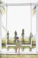 A young woman sits on a swing and admires the breathtaking view of beautiful nature. photo