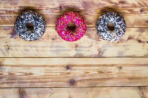 Donuts on wooden background. Sweet foods flat lay with copy space. Food mock up image. High quality photo