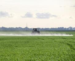 Tractor with a spray device for finely dispersed fertilizer. photo