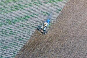 Top view of the tractor that plows the field. disking the soil. Soil cultivation after harvest photo