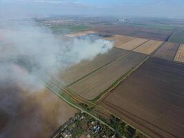 parte superior ver de el pequeño aldea. fumar desde el ardiente de Paja es untado terminado el pueblo foto