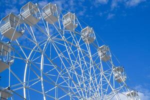 White ferris wheel against the blue sky. Ferris wheel in the park photo
