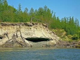 Crumbled cliff on the river bank. photo
