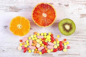 Fresh fruits and colorful medical pills, choice between healthy nutrition and medical supplements photo