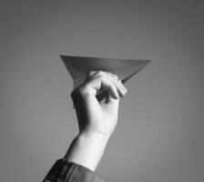 White paper airplane in hand against the sky. A symbol of freedom on the Internet photo