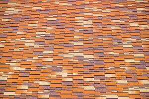 Roof from multi-colored bituminous shingles. Patterned bitumen shingles. photo