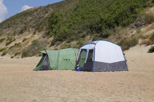Tourist tent on the sand. Parking of tourists on the sandy beach photo