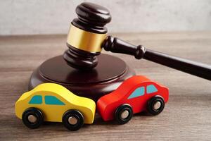 Car accident lawsuit and insurance, Judge hammer with car model. photo