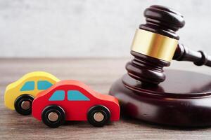 Car accident lawsuit and insurance, Judge hammer with car model. photo