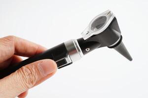 Otoscope isolated on white background for otolaryngologist or ENT physician doctor examining senior patient ear, hearing loss problem. photo