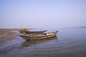 landscape view of Some wooden fishing boats on the shore of the Padma river in Bangladesh photo