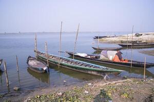 landscape view of Some wooden fishing boats on the shore of the Padma river in Bangladesh photo