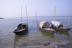 landscape view of Some wooden fishing boats on the shore of the Padma river in Bangladesh photo