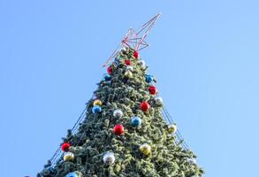 decoraciones nuevo año árbol. oropel y juguetes, pelotas y otro decoraciones en el Navidad Navidad árbol en pie en el abierto aire. foto